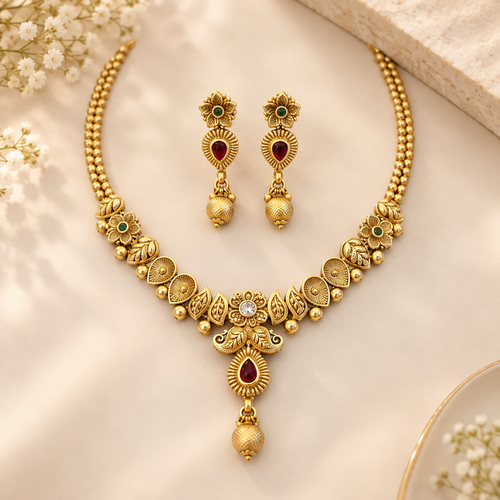 Gold-tone brass necklace set with matching drop earrings on a clean neutral background