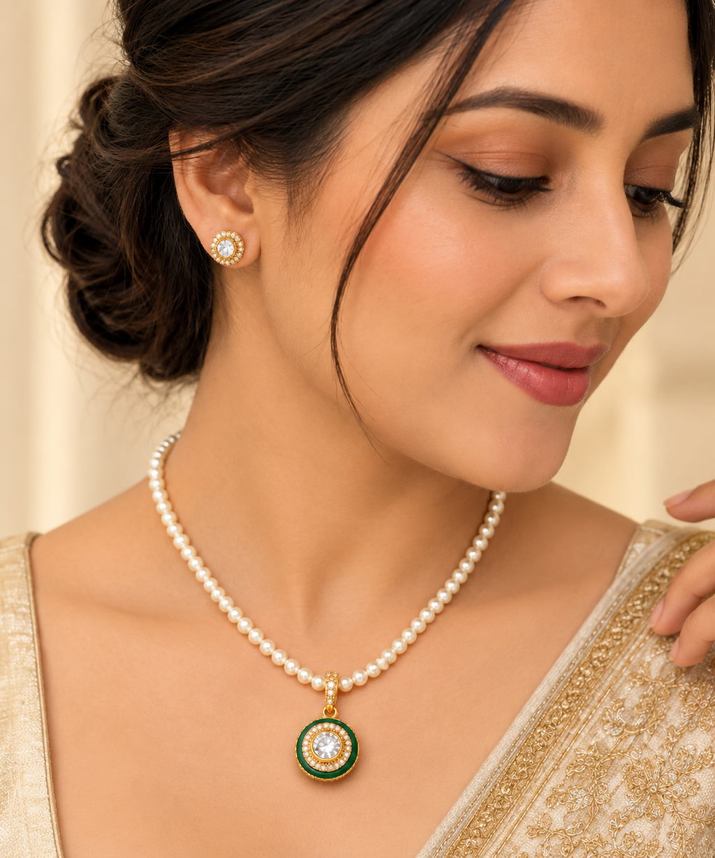 Indian model wearing a pearl-beaded necklace with green Kundan pendant and matching stud earrings