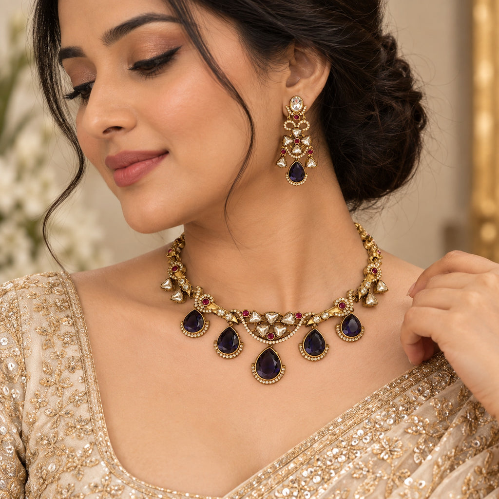 Indian woman wearing a purple and gold AD jewellery set with an ornate necklace and matching long earrings